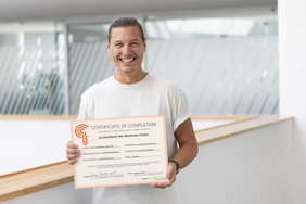 Mitarbeiter von doubleSlash hält ein CCC-Zertifikat für den Digital Key in den Händen.