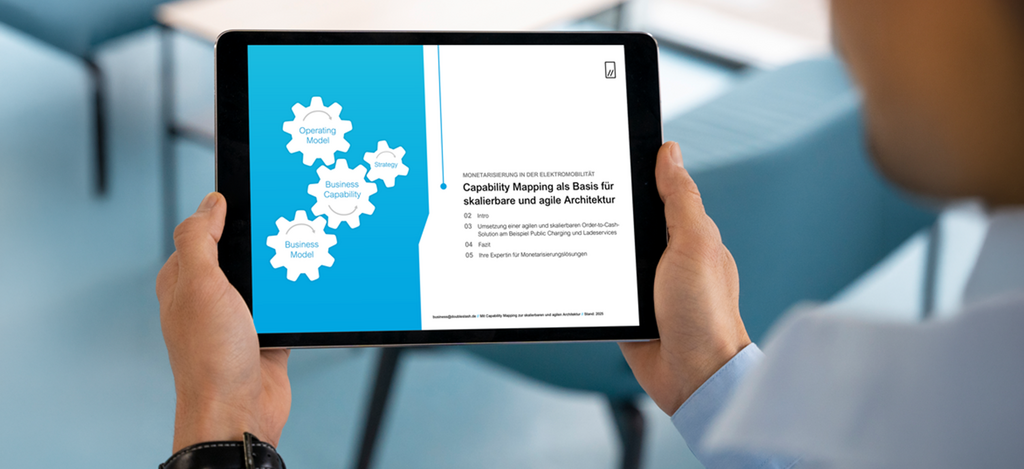 Tablet in den Händen einer Person zeigt ein Dokument zu „Capability Mapping“ mit Zahnrädern für Business Model, Capability und Strategy.