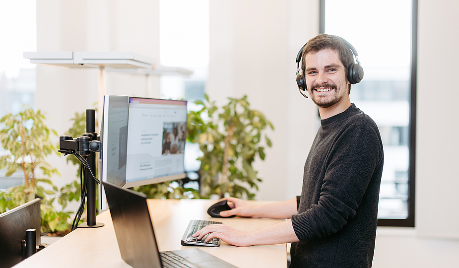 Mann steht am Schreibtisch im Büro
