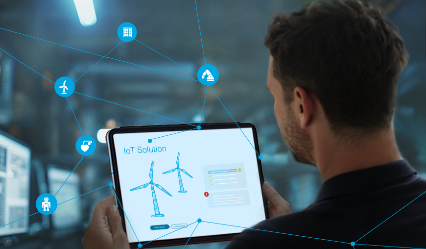 Keyvisual IoT: Mann schaut auf ein Tablet mit vernetzten Windrädern