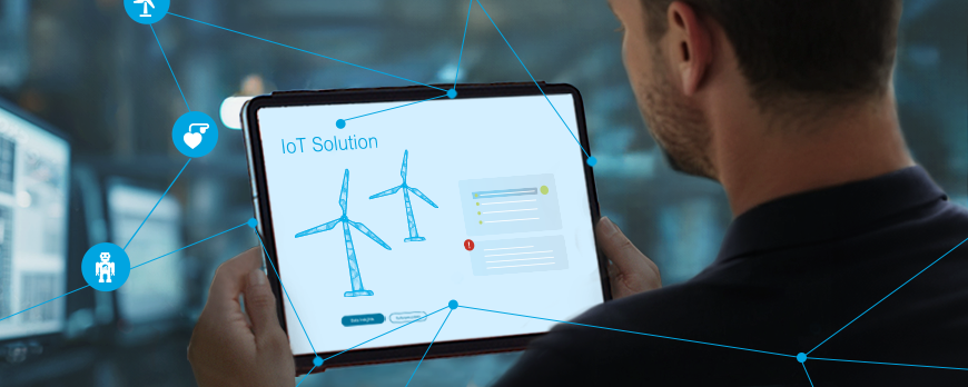 Keyvisual IoT: Mann schaut auf ein Tablet mit vernetzten Windrädern