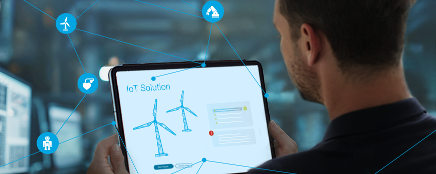 Keyvisual IoT: Man looking at a tablet with networked wind turbines