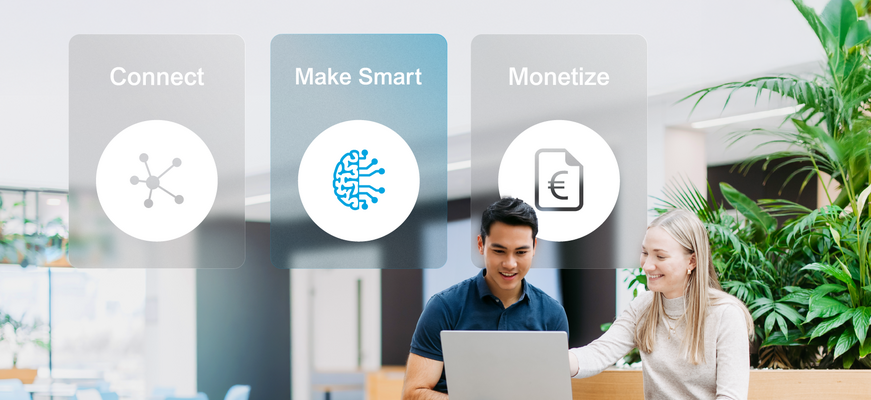 Two employees with laptops in a bright office environment; above them, the four service areas “Connect,” “Make Smart,” and ‘Monetize’ are displayed as visual navigation tiles. “Make Smart” is highlighted. – AI-generated image