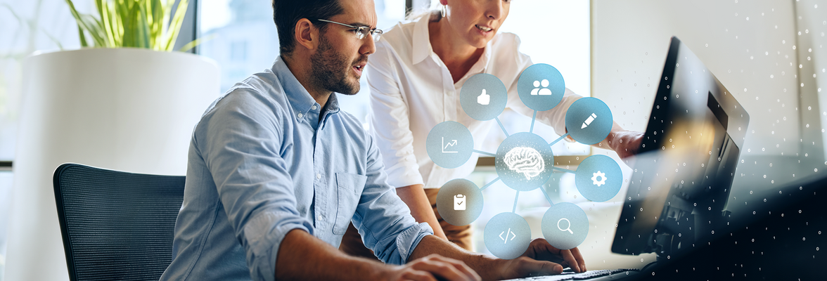 Zwei Personen arbeiten gemeinsam am Computer; darüber eine Grafik mit vernetztem Gehirn-Symbol und Icons für Daten, Analyse und digitale Prozesse.