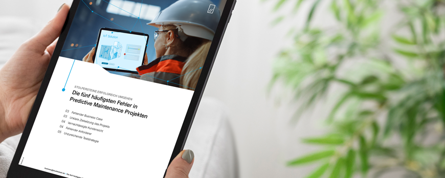 Person holding a tablet displaying a page about predictive maintenance and IoT content.