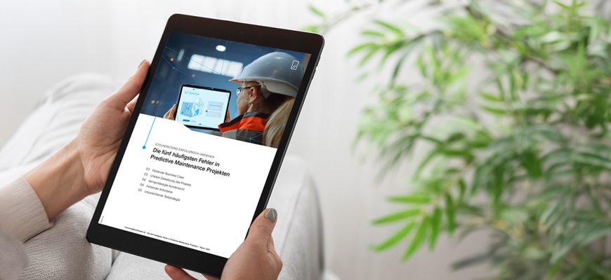 Person hält ein Tablet mit einer Seite zu Predictive Maintenance und IoT-Inhalten auf dem Bildschirm.