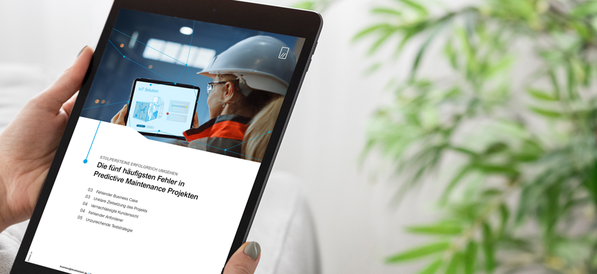 Person hält ein Tablet mit einer Seite zu Predictive Maintenance und IoT-Inhalten auf dem Bildschirm.