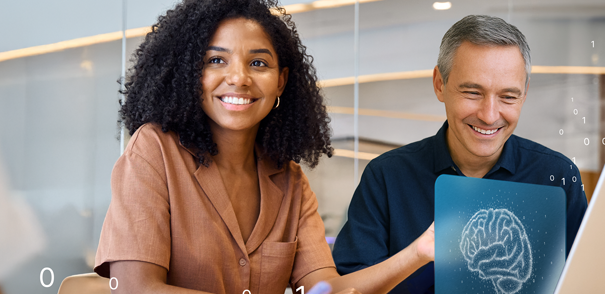 Zwei Personen sitzen gemeinsam an einem Laptop in einem modernen Büro. Vor ihnen steht ein Laptop. Über dem Laptop schwebt das Bildschirmbild mit einem Gehirn. Es schweben weitere 0 und 1 durch das Bild.