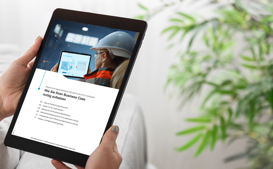 Person hält ein Tablet mit einer Seite zu Predictive Maintenance und IoT-Inhalten auf dem Bildschirm.