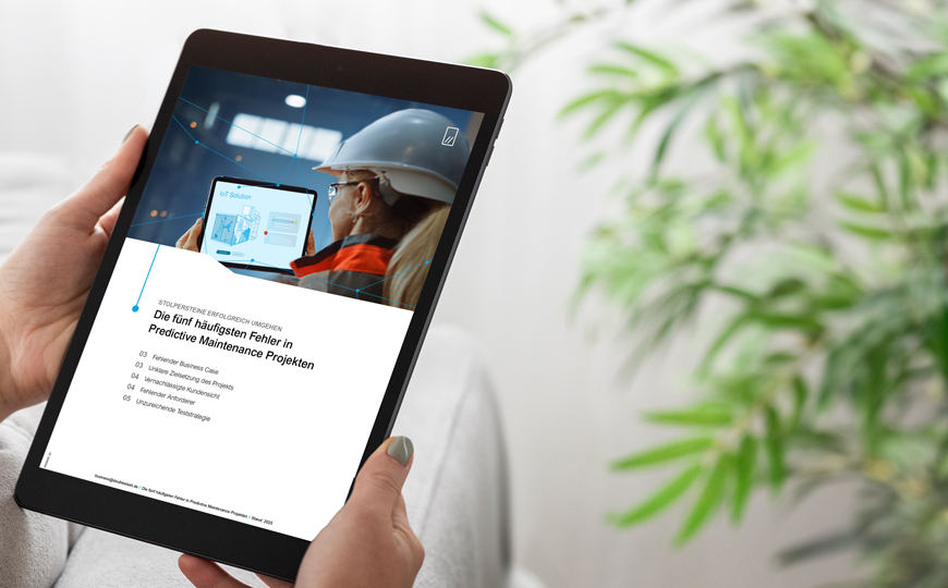 Person hält ein Tablet mit einer Seite zu Predictive Maintenance und IoT-Inhalten auf dem Bildschirm.