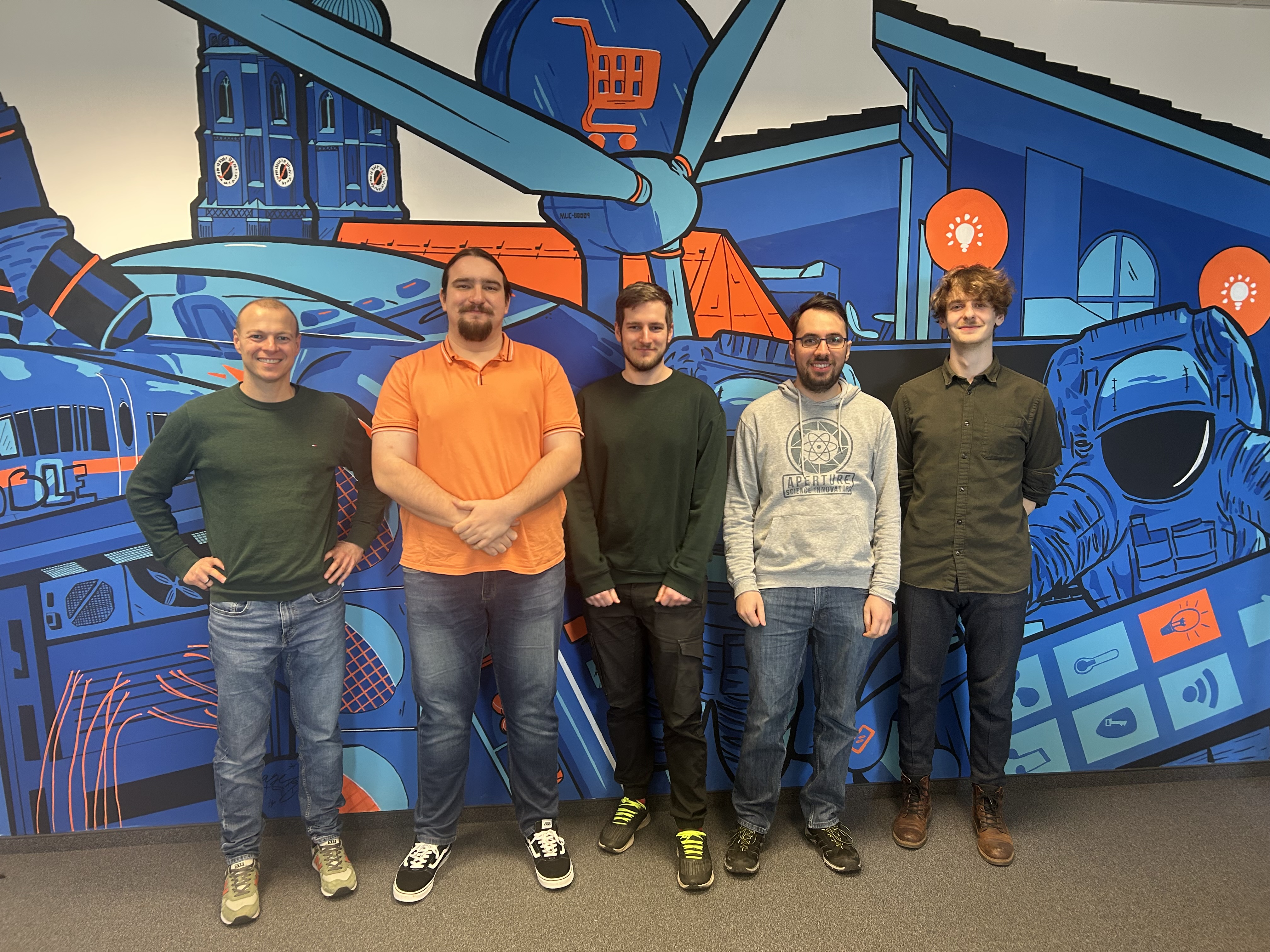 5 Personen vor bunter Wand